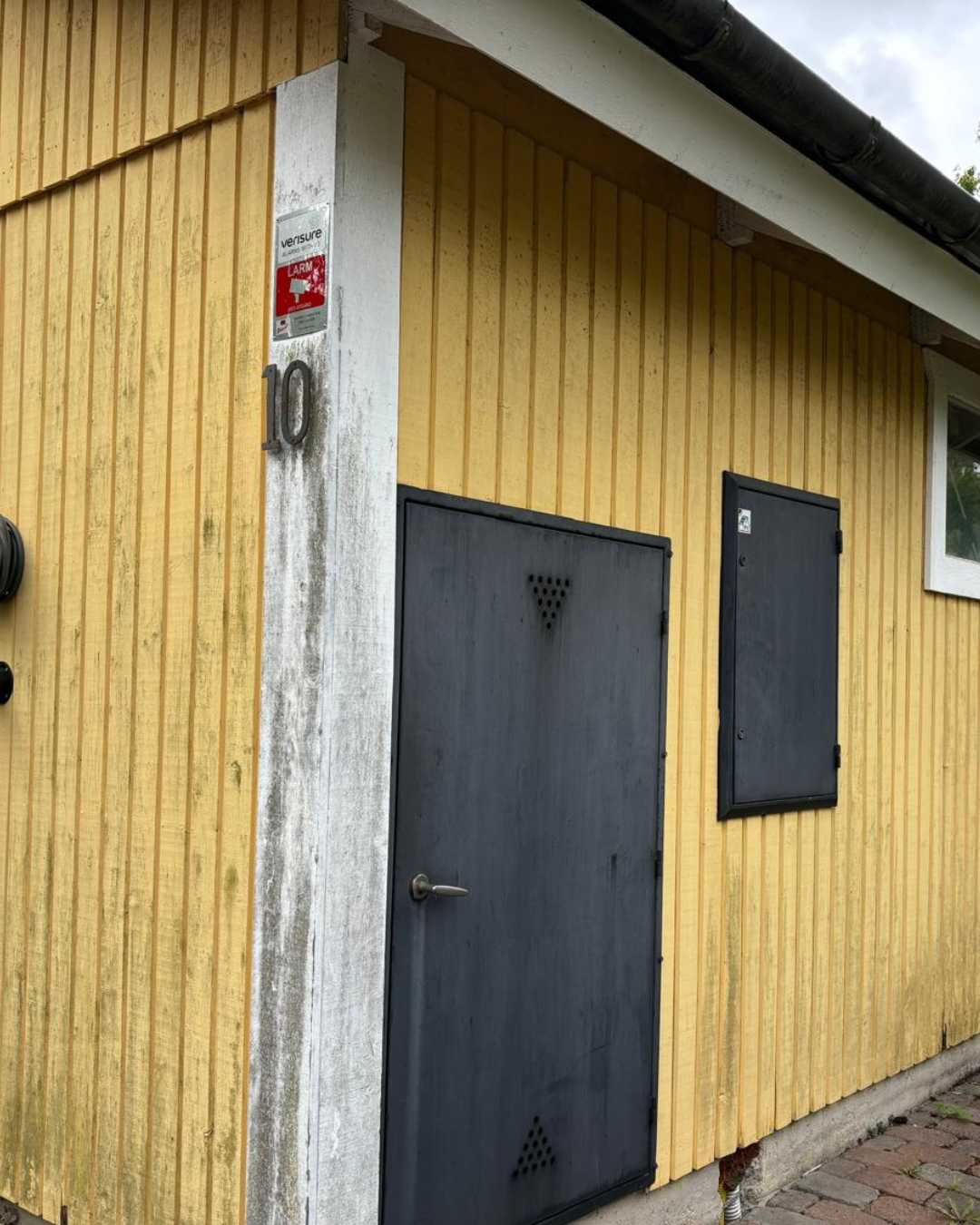 Träfasad med grånad, obehandlad yta.